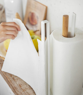 Close up view of white Paper Towel Holder holding paper towel on kitchen shelf by Yamazaki Home. view 6