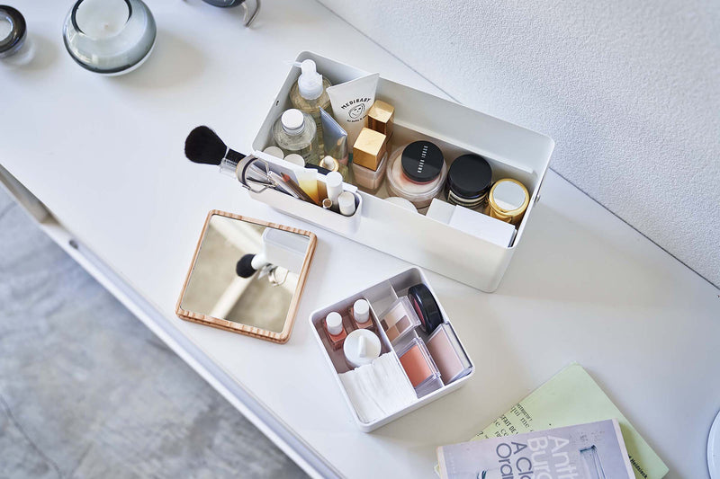 Aerial view of open white Makeup Organizer and comparments holding makeup products on table by Yamazaki Home.