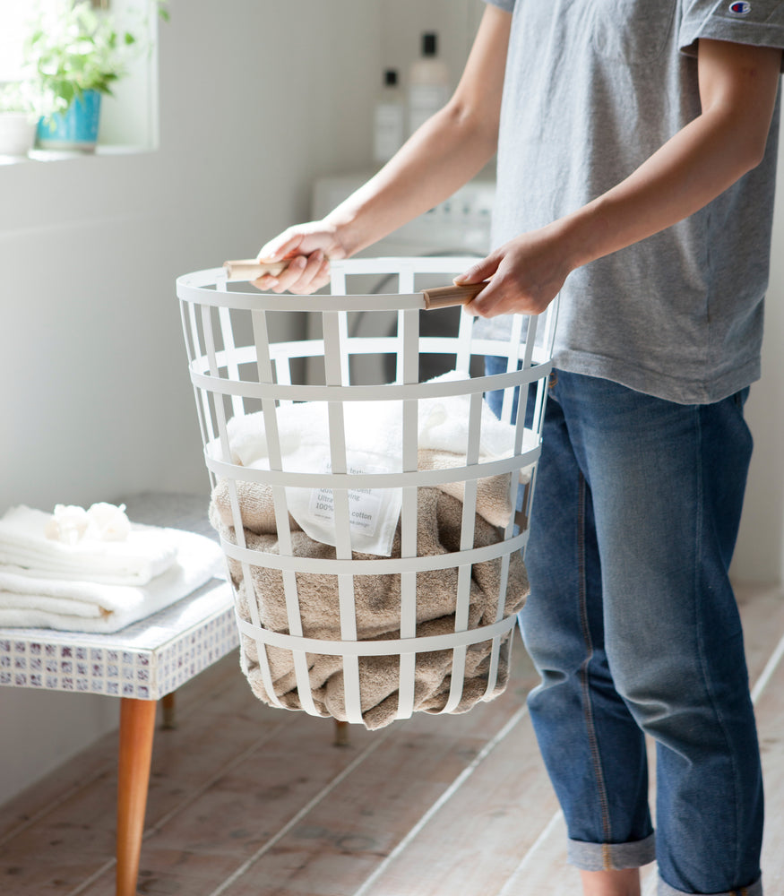 View 4 - White Round Laundry Basket holding towels in laundry room by Yamazaki Home.