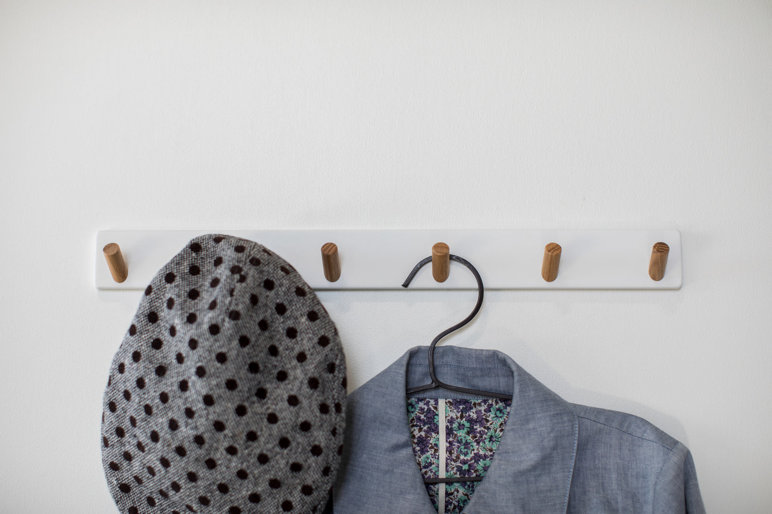 View 4 - Front view of white Wall-Mounted Coat Hanger holding hat and jacket by Yamazaki Home.