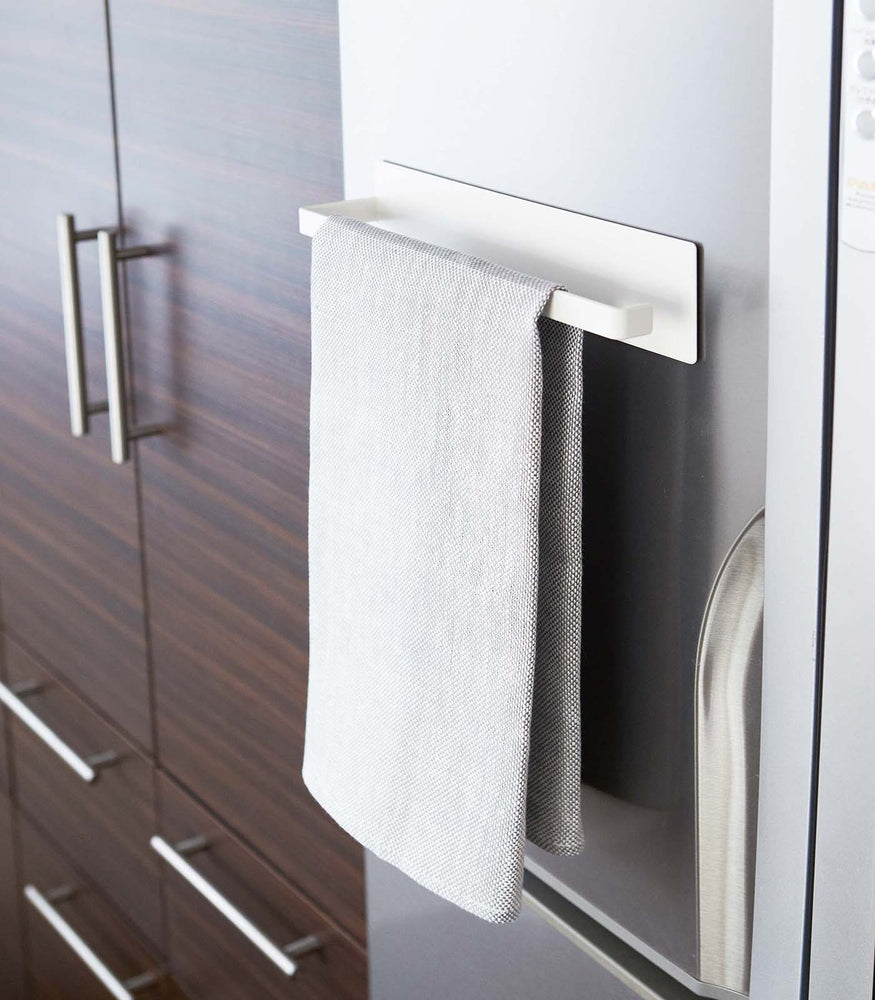 View 4 - White Magnetic Paper Towel Holder holding dish towel in kitchen by Yamazaki Home.