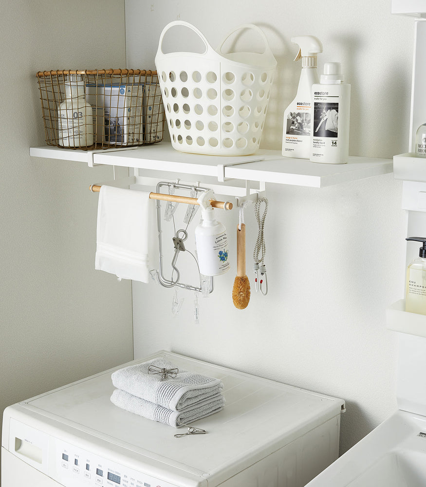 View 4 - White Undershelf Hanger in laundry room holding cleaning items by Yamazaki Home.