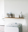 Wall-Mounted Shelf holding cleaning items in laundry room by Yamazaki Home.