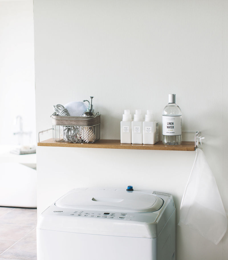 Wall-Mounted Shelf holding cleaning items in laundry room by Yamazaki Home.
