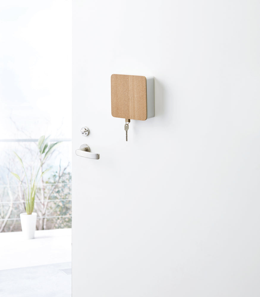 View 2 - White Square Magnetic Key Cabinet with Hooks holding key on door by Yamazaki Home.