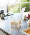 White Pantry Organizer open holding rice on kitchen countertop by Yamazaki Home.