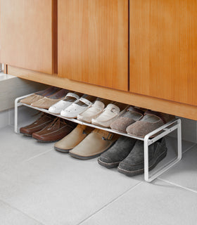 White Stackable Shoe Rack in bedroom by Yamazaki Home. view 4