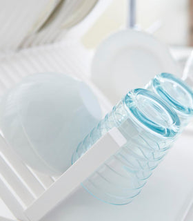 Close up of white X-Shaped Dish Rack holding cups and bowls by Yamazaki Home. view 6