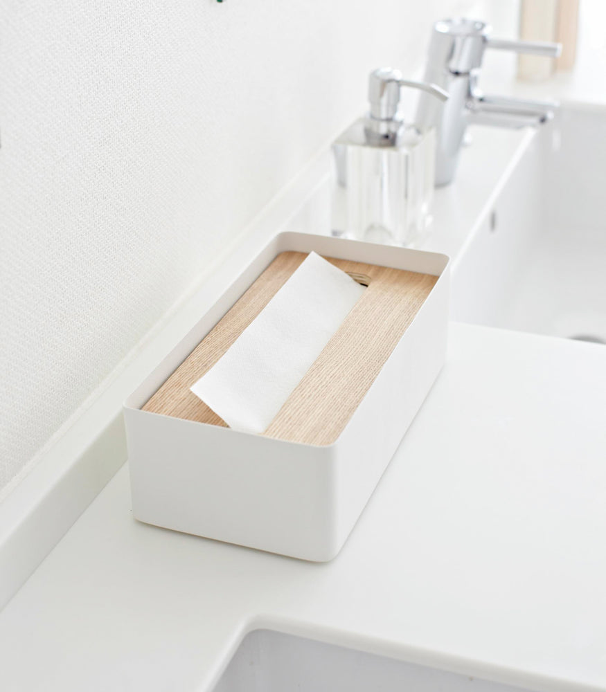 View 3 - Aerial side view of white Tissue Case on bathroom sink counter by Yamazaki Home.
