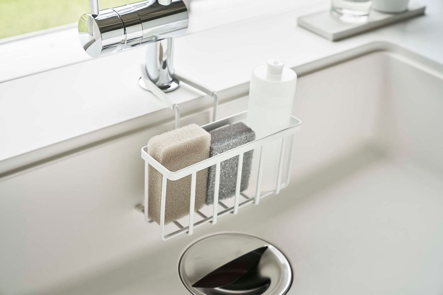 View 5 - Side view of Yamazaki Home white Faucet-Hanging Sponge Caddy in a sink