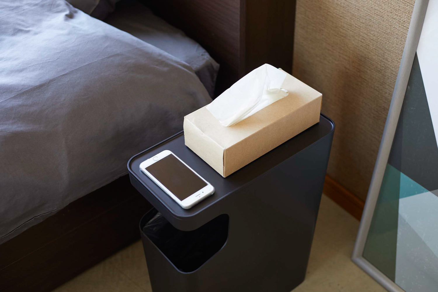 View 11 - Aerial view of black Side Table Trash Can displaying tissue box and phone in bedroom by Yamazaki Home.