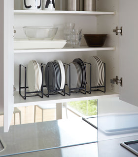 Black Dish Storage Rack holding plates in kitchen cabinet by Yamazaki Home. view 8