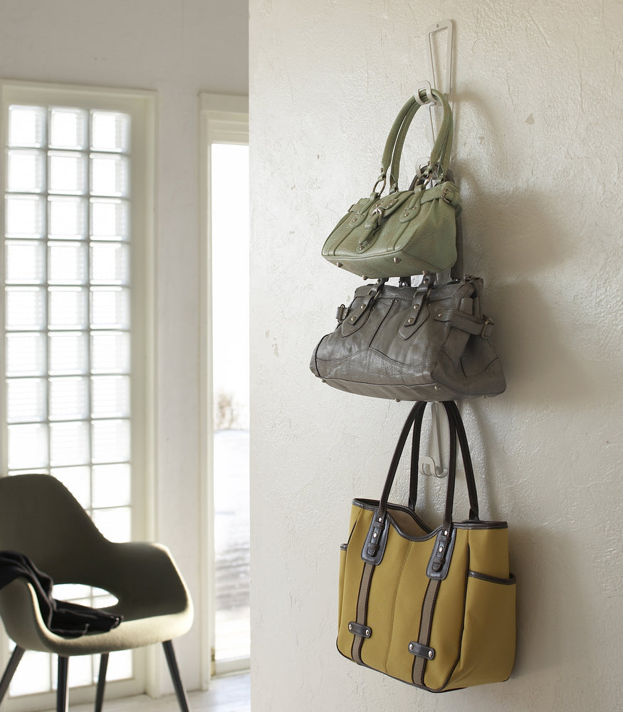 View 5 - White Chain Link Bag Hanger holding purses on wall by Yamazaki Home.