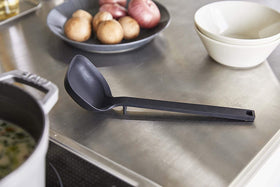 Side view of black Floating Ladle on kitchen counter by Yamazaki Home. view 2