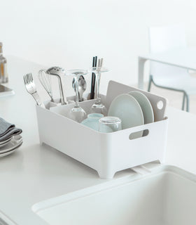 Side view of white Dish Rack containing dishware on kitchen counter by Yamazaki Home. view 3