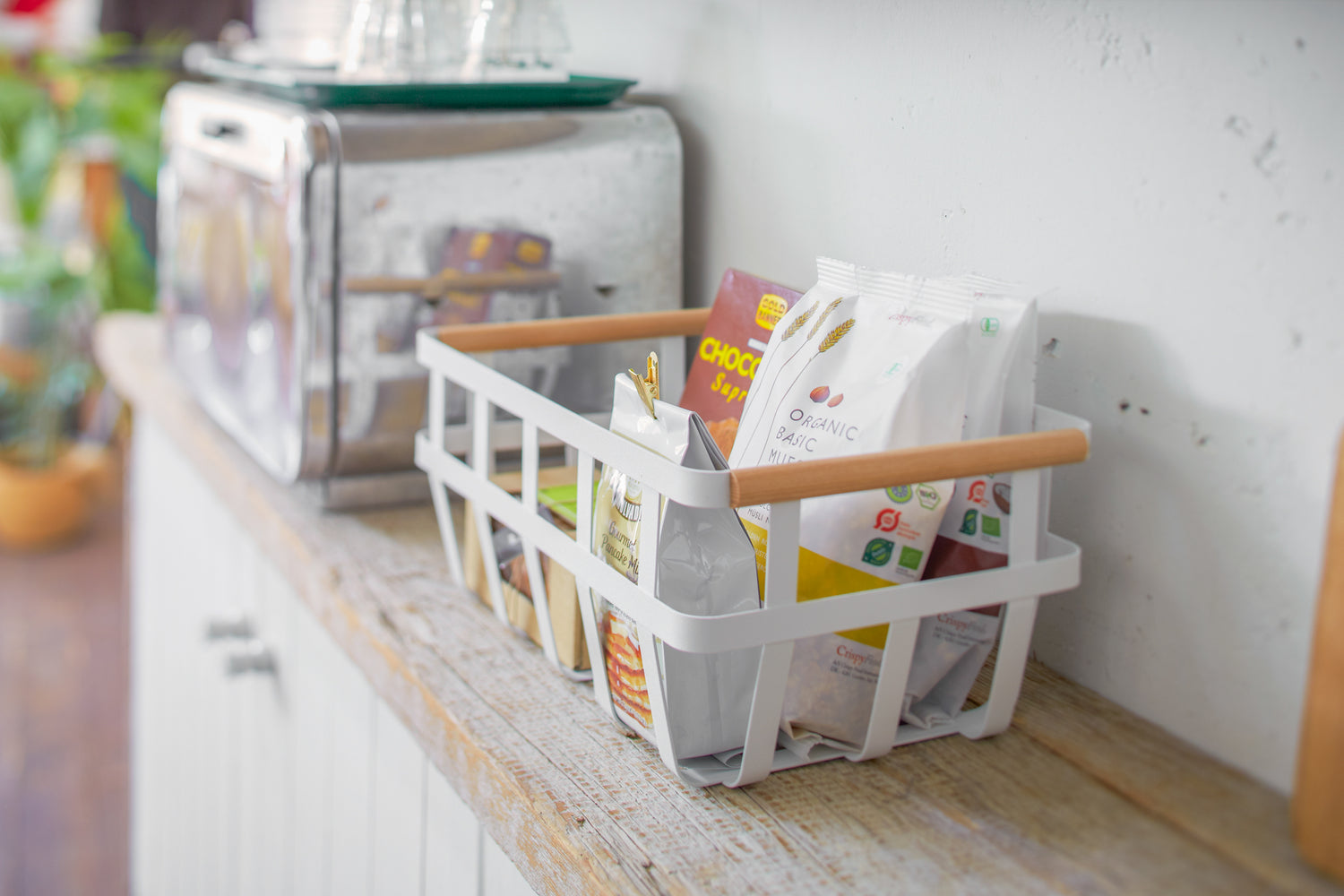 View 10 - Side view of white Storage Basket holding snack food on shelf by Yamazaki Home.