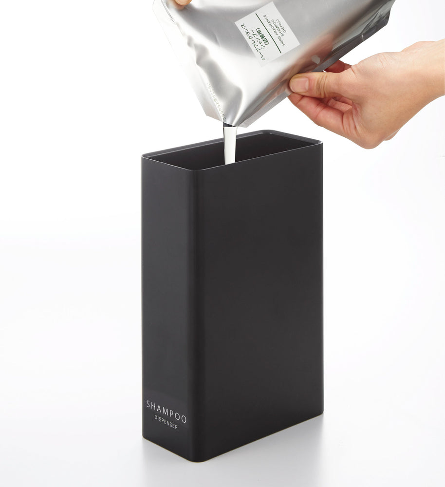 View 15 - Black Shampoo Dispenser getting filled with shampoo on white background by Yamazaki Home.