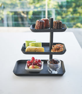 Front view of black Serving Stand displaying desserts and fruit on white table by Yamazaki Home. view 10