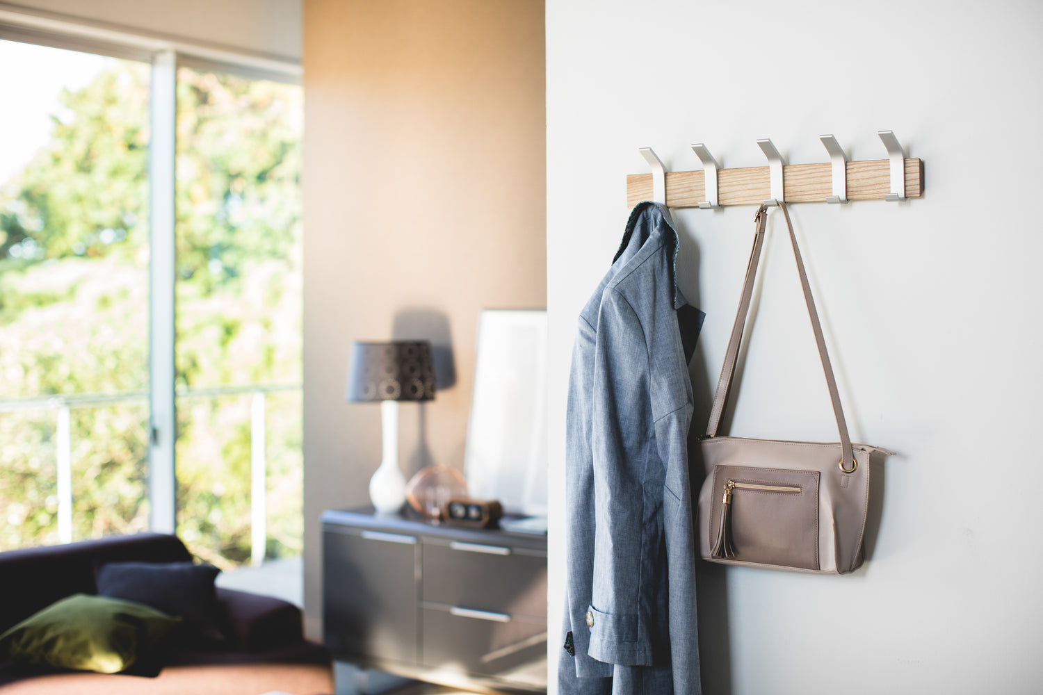 View 3 - Ash Wall-Mounted Coat Hanger holding jacket and purse by Yamazaki Home.