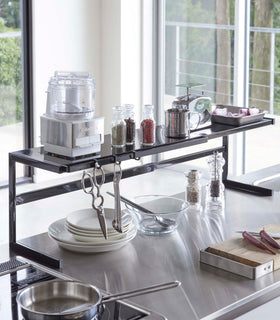 Black Expandable Kitchen Support Rack displaying kitchen items over stovetop by Yamazaki Home. view 13
