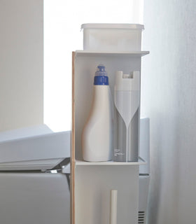 Side view of Toilet Paper Stocker holding bathroom cleaning items and accessories in bathroom by Yamazaki Home. view 7
