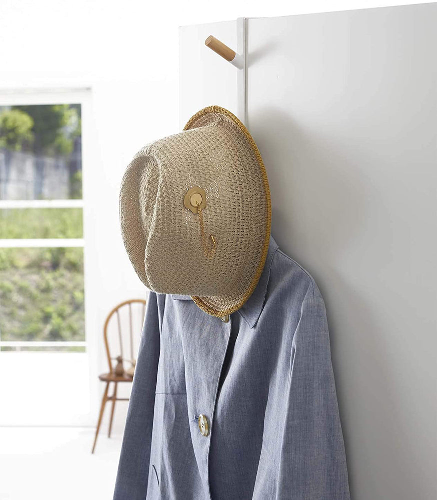 View 2 - White Over-the-Door Hook on door holding hat and jacket by Yamazaki Home.