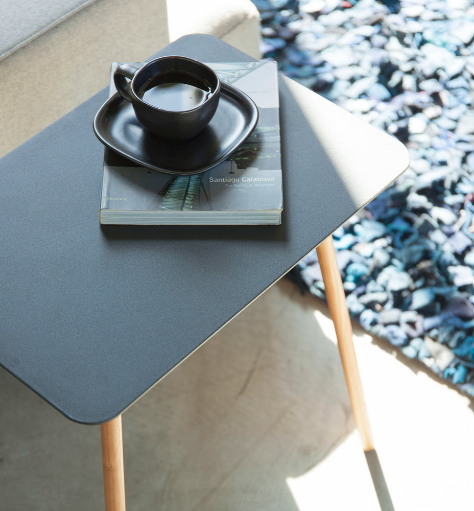 View 10 - Aerial view of black Side Table holding coffee cup and book by Yamazaki Home.