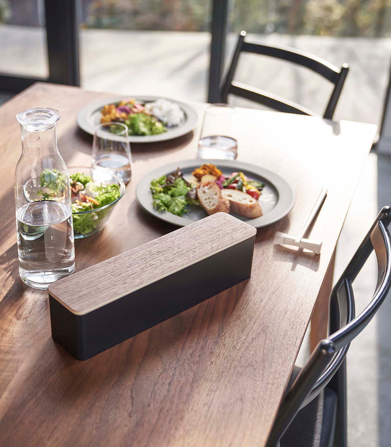 Closed black Utensil Case on dining table by Yamazaki Home.