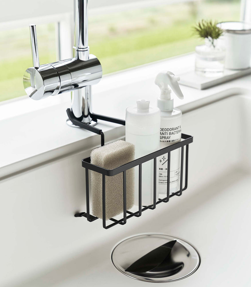 View 9 - Side view of Yamazaki Home black Faucet-Hanging Sponge Caddy in a sink