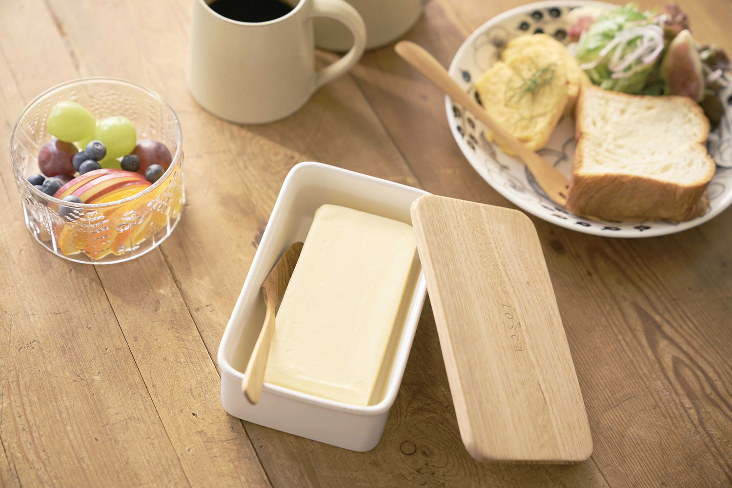 View 6 - Aerial view of ceramic butter dish holding butter on breakfast table by Yamazaki Home.