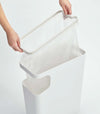 White Side Table Trash Can with plastic bag on white background by Yamazaki Home.