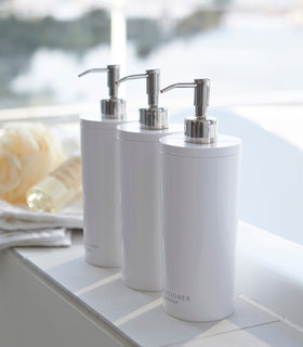 Yamazaki Home white Shampoo, Conditioner, and Body Soap dispensers in bathroom. view 2