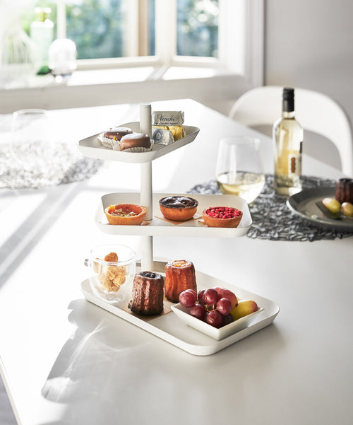Front view of white Serving Stand displaying desserts on white tabletop by Yamazaki Home.