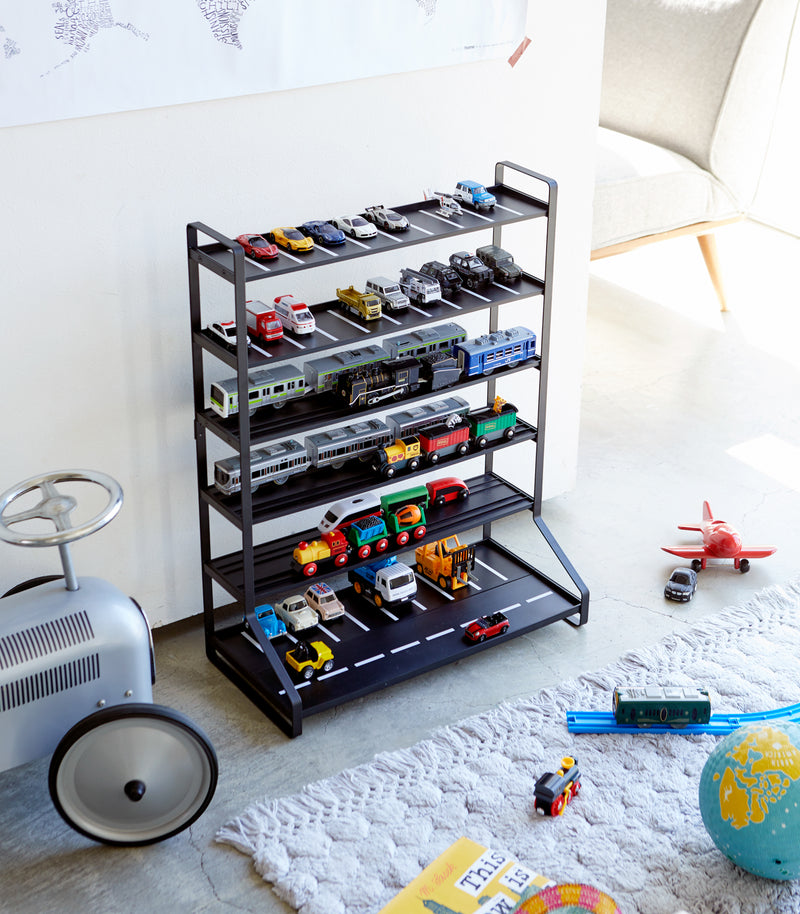 Black Kids' Parking Garage displaying toy trains and cars in playroom by Yamazaki Home.