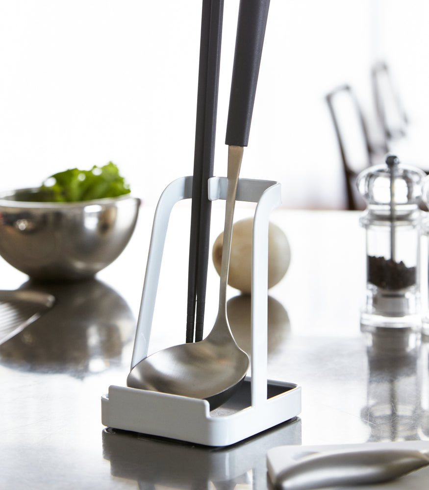 View 4 - White Lid & Ladle Stand holding ladle and tongs on kitchen counter by Yamazaki Home.