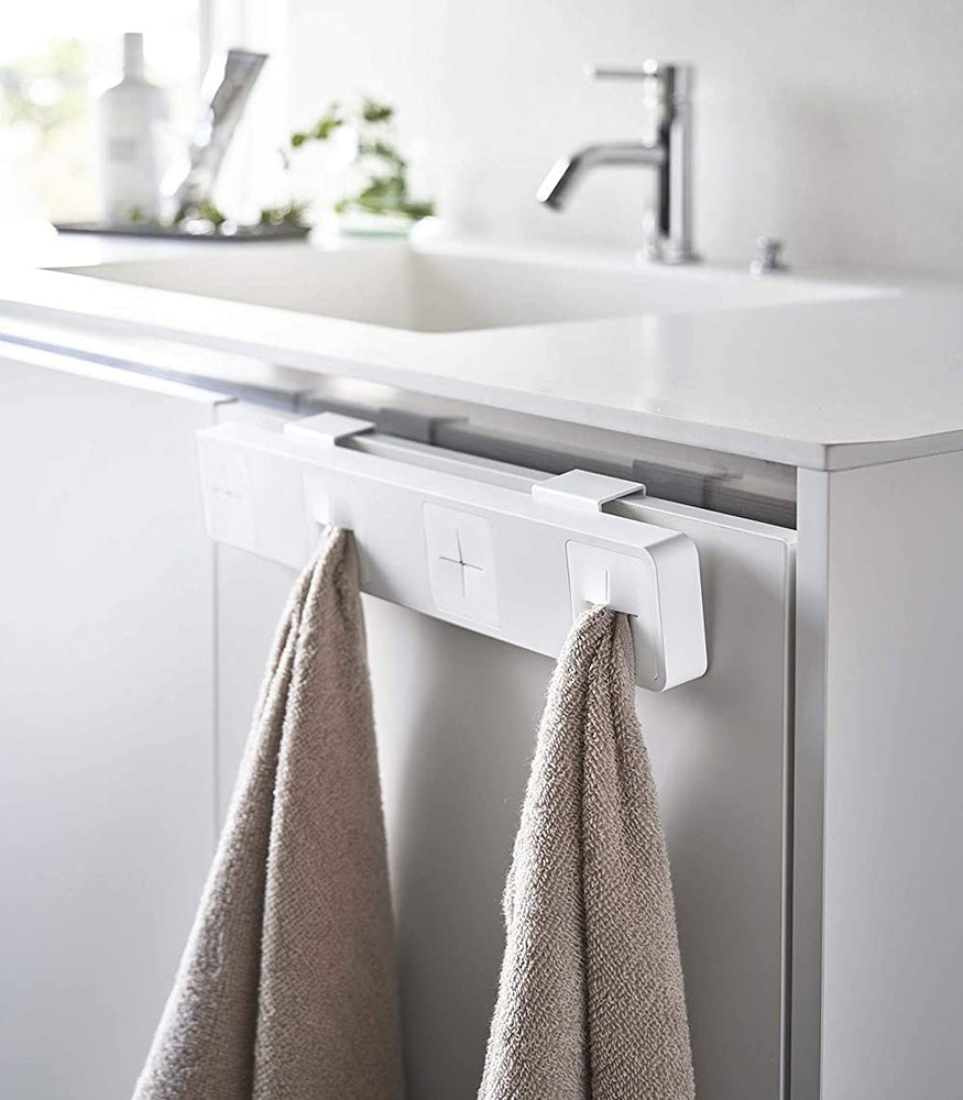 View 5 - White Push Dish Towel Holder holding towels in bathroom by Yamazaki Home.