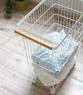 Close up view of Rolling Wire Basket holding clothes by Yamazaki Home. view 6