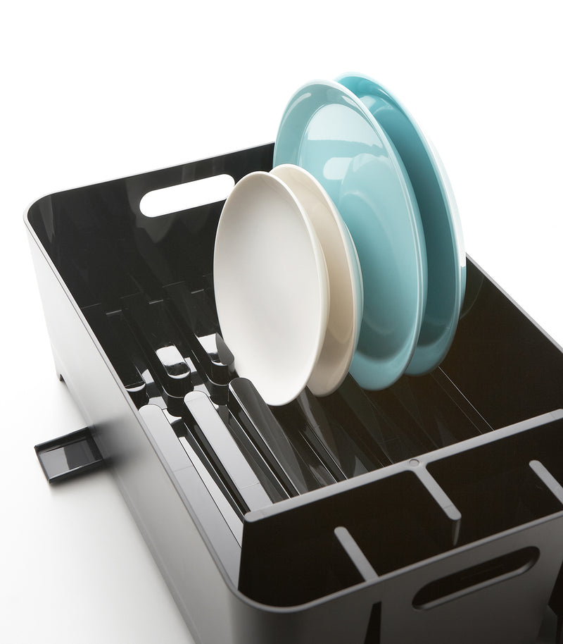 Black Dish Rack holding plates on white background by Yamazaki Home.
