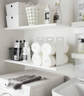 White Towel Storagae Organizers holding towels on laundry room shelf by Yamazaki Home. view 4