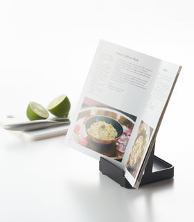 Black Lid & Ladle Stand holding cookbook on white background by Yamazaki Home. view 11