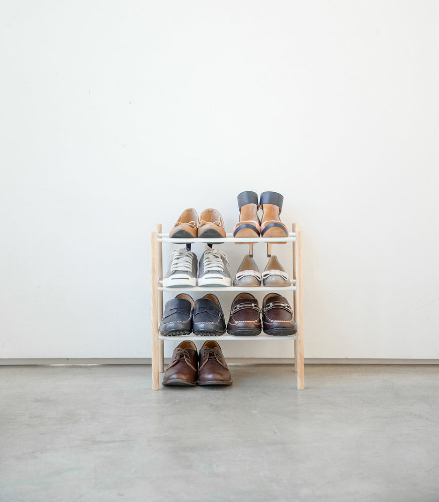 View 3 - Front view of entryway Expandable Shoe Rack holding shoes by Yamazaki Home.