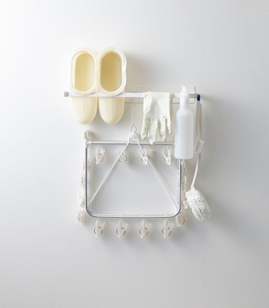 View 3 - Front view of white Magnetic Clothes Hanger holding cleaning items by Yamazaki Home.
