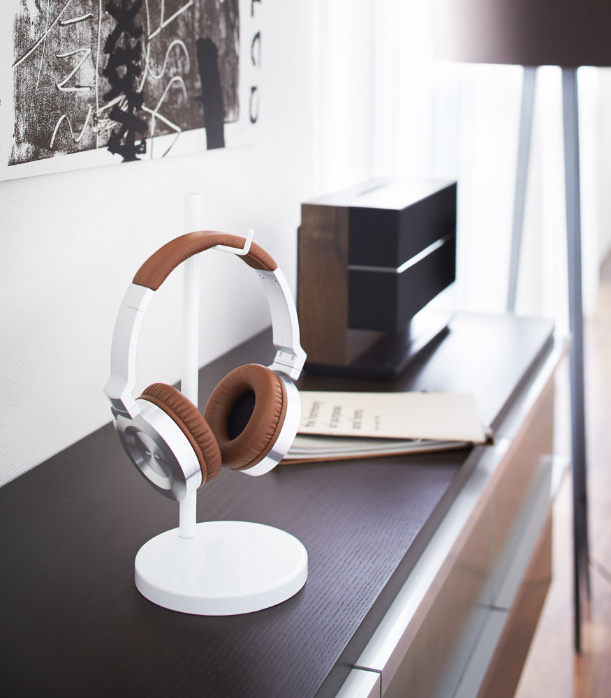View 3 - White Headphone Stand holding headphones on bureau by Yamazaki Home.
