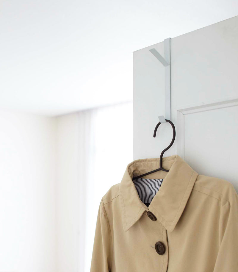 White Over-the-Door Hanger displaying jacket on door by Yamazaki Home.