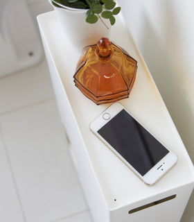 Close up aerial view of white Toilet Paper Stocker top holding plant, jar, and phone in bathroom by Yamazaki Home. view 7