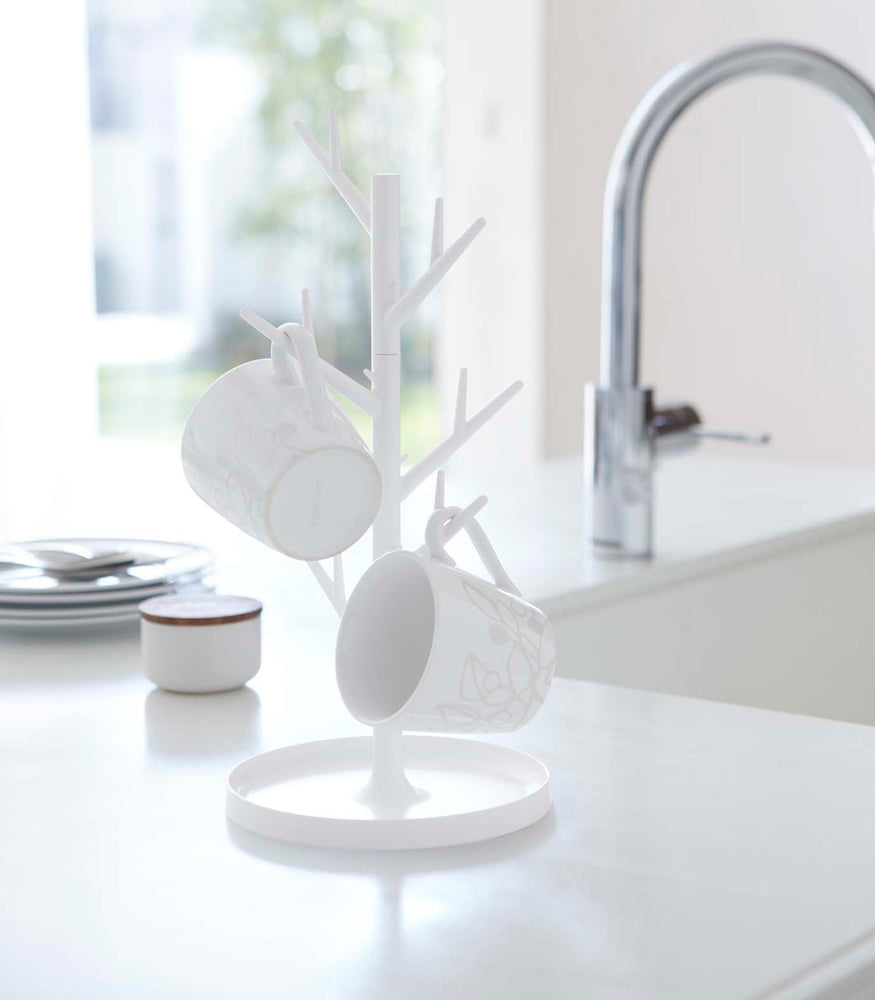 View 3 - White Glass & Mug Tree holding mugs on sink countertop by Yamazaki Home.