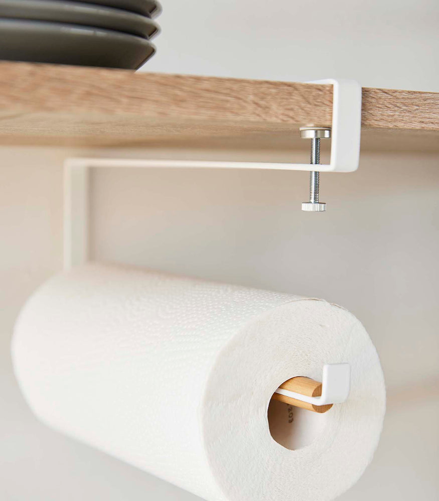View 4 - Close-up view of Undershelf Paper Towel Holder holding paper towels and attached to shelf by Yamazaki Home.