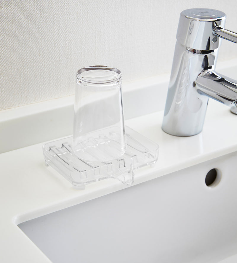Clear Self-Draining Soap Tray holding soap bar on sink counter by Yamazaki Home.