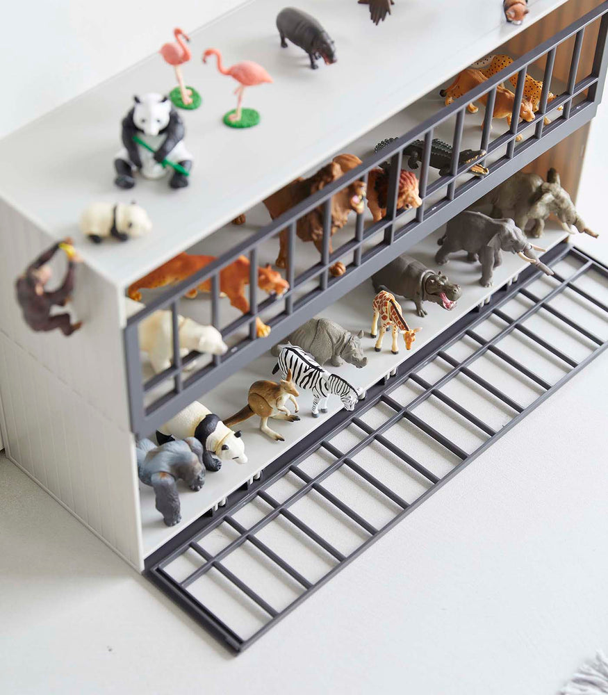 View 5 - Aerial view of white Two-Tier Toy Dinosaur and Animal Storage Rack holding toy animals by Yamazaki Home.