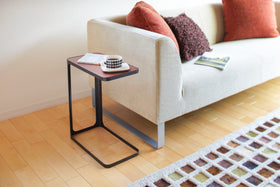 Black C Side Table holding coffee and book next to living room couch by Yamazaki Home. view 6